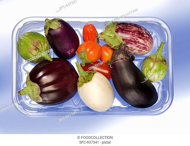 Various types of aubergines in a plastic tray