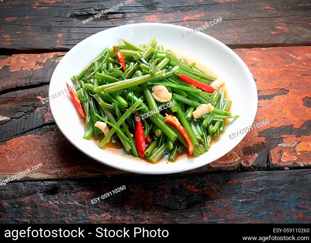 Top view Thai food stir fried morning glory isolated on rustic wooden table
