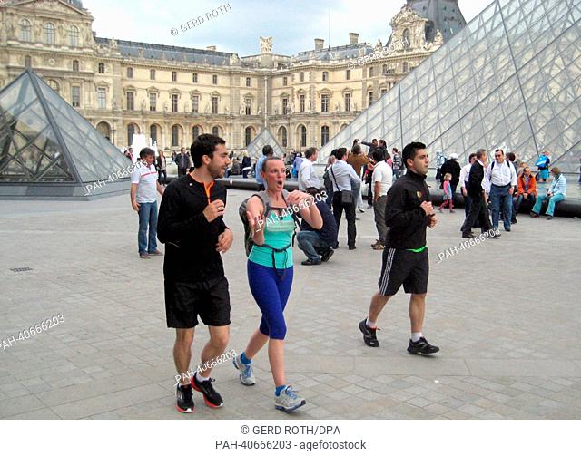 German journalist Lea Hofmann (C) and two tourists, Nicolas Cahen (R) und Anthony da Cruz (L), look at a map at the Louvre in Paris, France, 01 June 2013