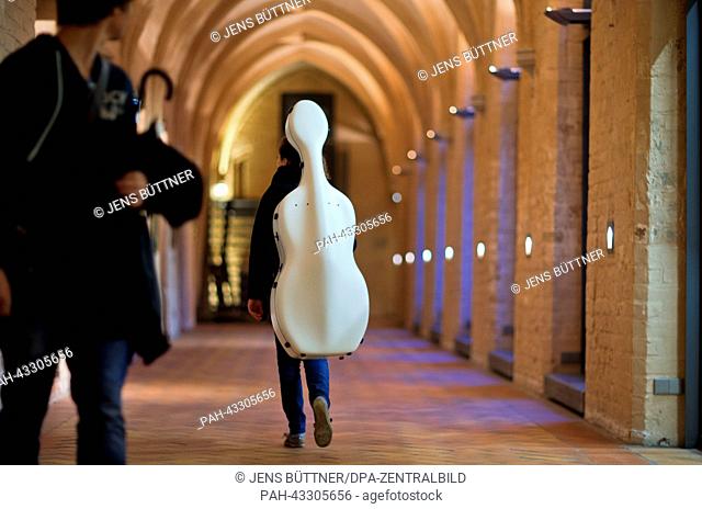 A student of the Rostock University of Music and Drama carries her cello through the cloister of the St. Catherine's Monastery in Rostock, Germany