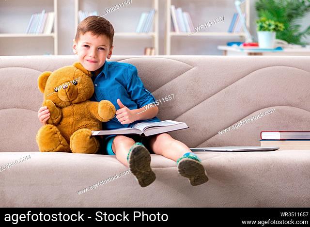Small boy reading books at home