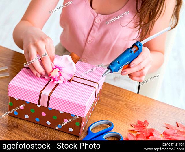 The woman decorating gift box for special occasion