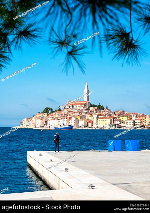 Rovinj old town with pier and woman photographing the city