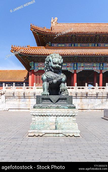 Ming-era Chinese imperial guardian lion bronze in front of a palace building at the Forbidden City in Beijing, China in March 2018