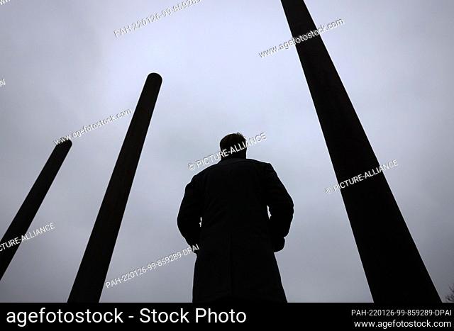 26 January 2022, North Rhine-Westphalia, Bonn: A man stands under a gray sky between steel columns in front of the Bundeskunsthalle