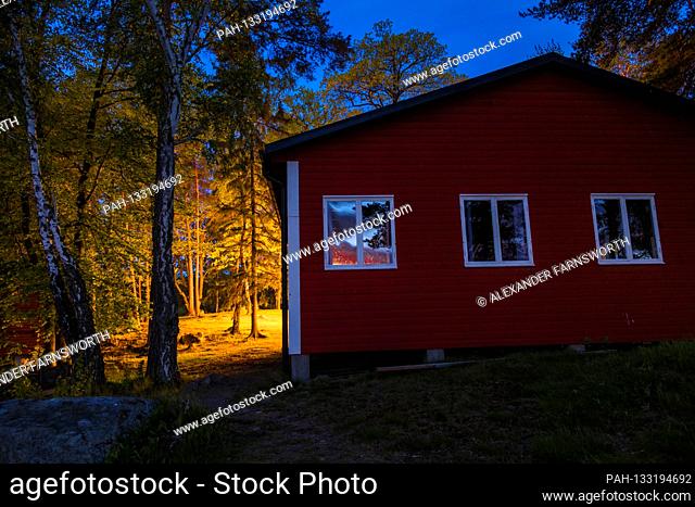 Stockholm, Sweden A red house at night on the Idskar island in Lake malaren. | usage worldwide. - STOCKHOLM/Sweden