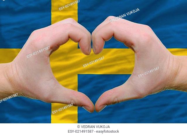 Heart and love gesture showed by hands over flag of sweden backg