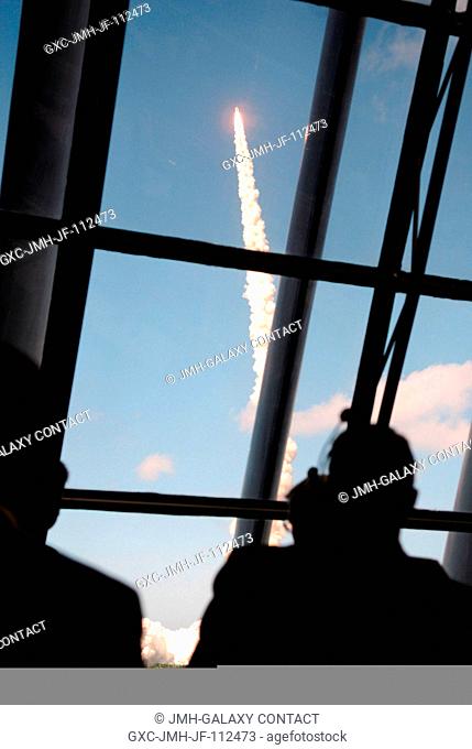 View of personnel watching the launch of Space Shuttle Discovery through the windows of the Launch Control Center at the Kennedy Space Center