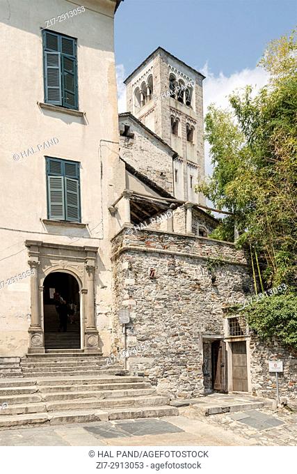 stone entrance portal and bell tower in background at Orta lake, shot on bright summer day on San Giulio island, Novara, Cusio, Italy