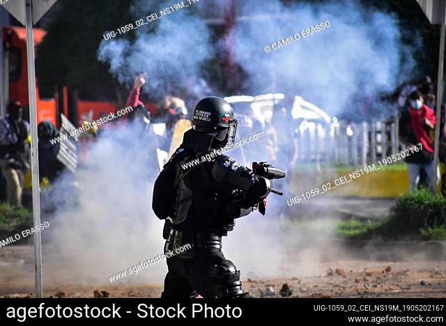 Riot police member aim their weapon directly at the demostratos body in Pasto, Narino on May 19, 2021 during an antigovernment protest against police brutality...