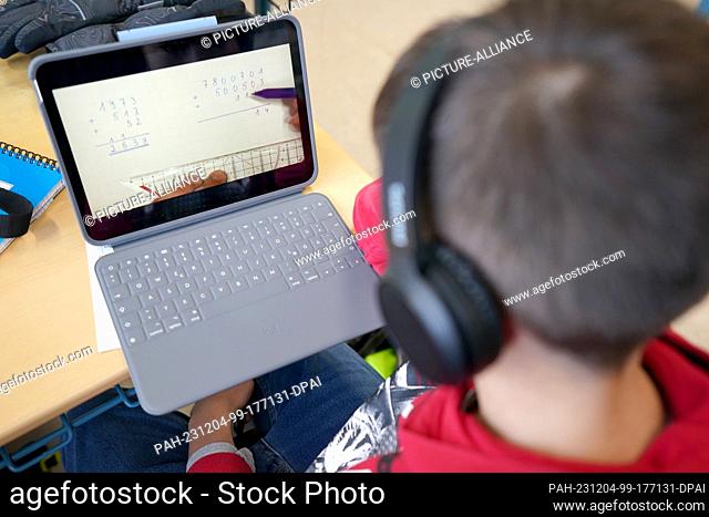 04 December 2023, Hamburg: A pupil works on a tablet during digital math lessons in class 5f at Lessing-Stadtteilschule in Harburg-Wilstorf