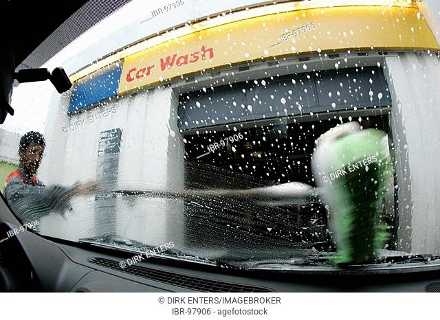 Car Wash - Employee cleans the windshield