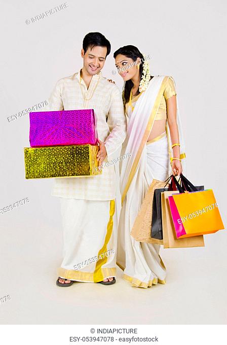 South Indian couple with shopping bags and gifts