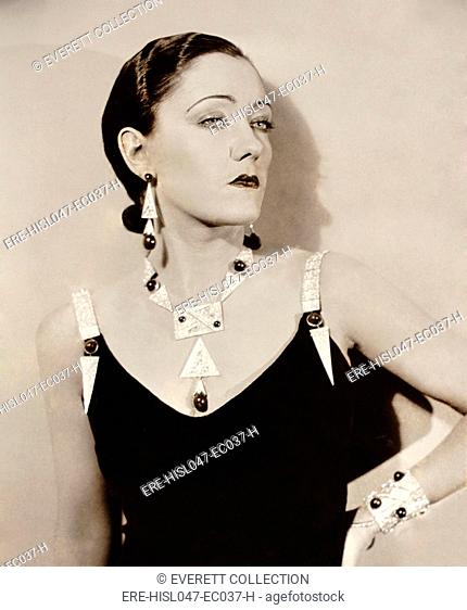 Actress Gloria Swanson models Art Deco jewelry c. 1930. She wears striking platinum geometric pieces studded with large gemstones