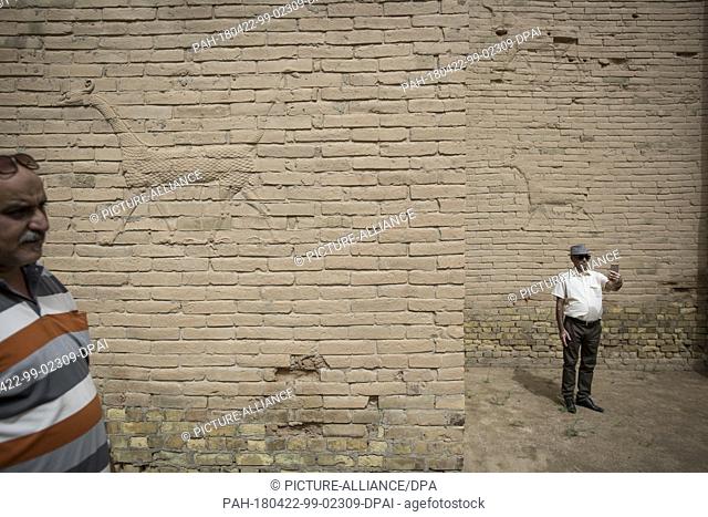dpatop - An Iraqi man takes a selfie in front of mystical figures decorating a wall in the ruins of the ancient city of Babylon in Hillah, Iraq, 22 April 2018