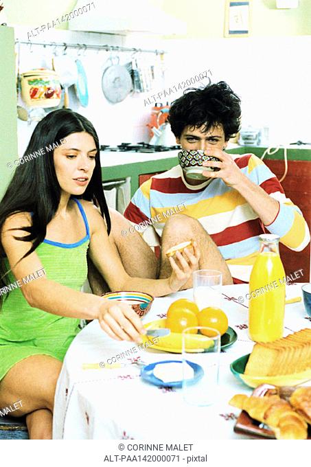Young couple sitting at table having breakfast