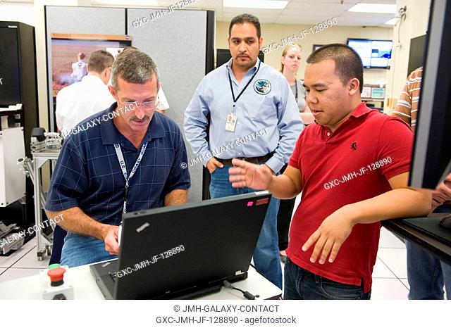NASA astronaut Dan Burbank (left), Expedition 29 flight engineer and Expedition 30 commander, uses a computer during a Robonaut familiarization training session...