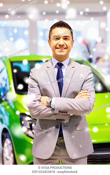 auto business, car sale, consumerism and people concept - happy man at auto show or salon over snow effect