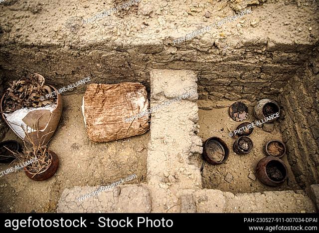 27 May 2023, Egypt, Saqqara: Ritual vessels used for mummification can be seen during the announcement of the discovery of two human and animal embalming...