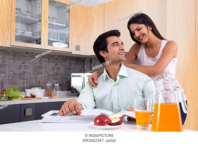 Young Indian couple spending leisure time in kitchen