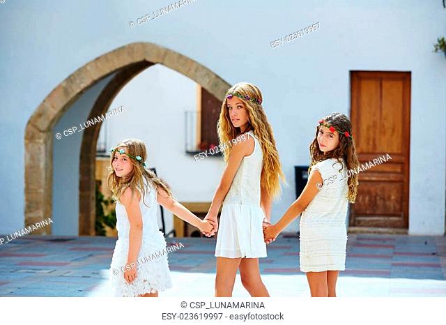 Kid girls walking hand in hand Mediterranean village