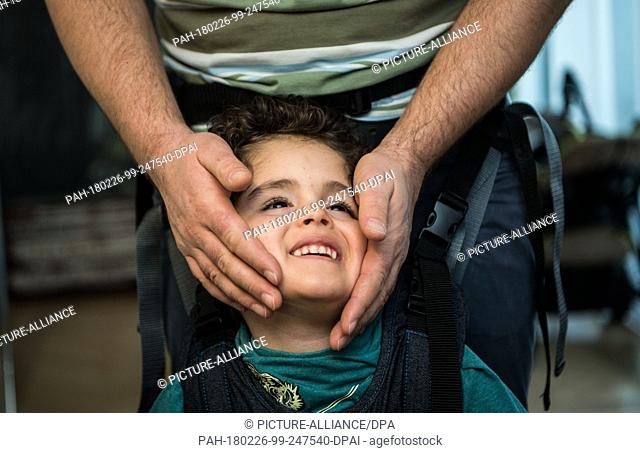 13 Febuary 2018, Germany, Mainz: Patrick Bager touches his son Caio's cheeks. He suffers from a rare CDKL5 gene defect. Photo: Andreas Arnold/dpa