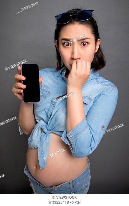 Pregnant women wearing the fashion with a cell phone