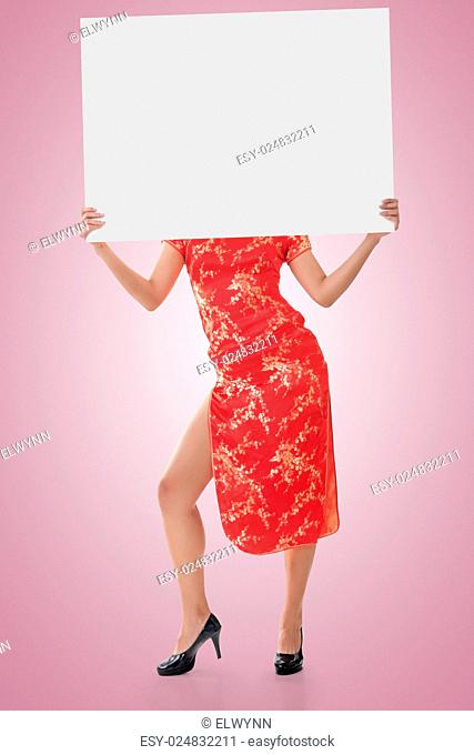 Attractive Chinese woman dress traditional cheongsam and hold blank board, full length portrait