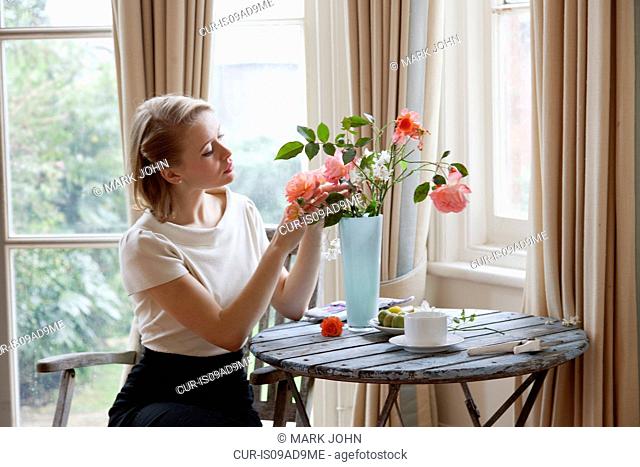 Woman arranging roses in vase