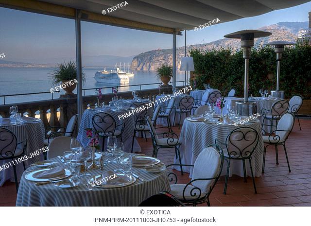 Empty tables and chairs at a restaurant on the terrace of a hotel, Sorrento, Campania, Italy