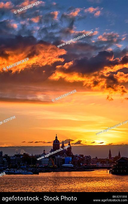 Amsterdam cityscape skyline with Church of Saint Nicholas (Sint-Nicolaaskerk) on sunset with dramatic sky. Amsterdam, Netherlands