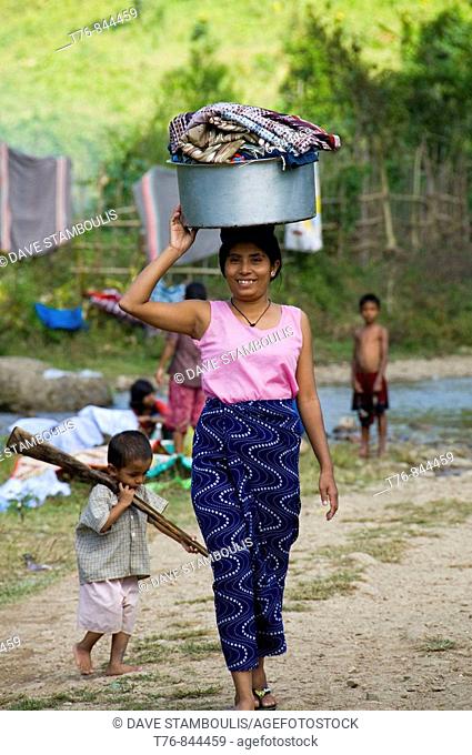 Burmese Karen refugee woman with her son and laundry in northern Thailand