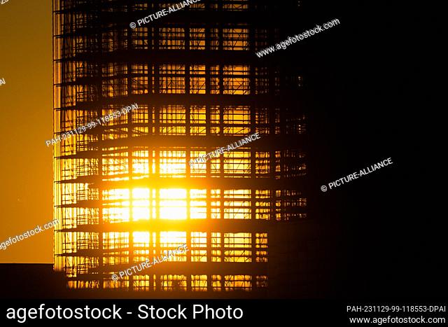 28 November 2023, Berlin: The sun sets behind the skeleton of the Steglitzer Kreisel skyscraper. Photo: Christoph Soeder/dpa. - Berlin/Berlin/Germany