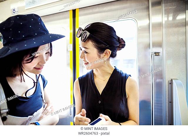 Two young woman traveling on a train