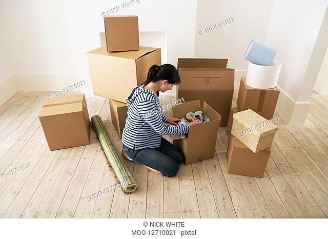 Woman Looking at Contents of Moving Boxes