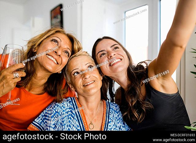 Happy young woman taking selfie with friends