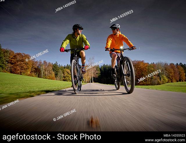 2 young men on bicycles, autumn, Oberambach, Bavaria, Germany