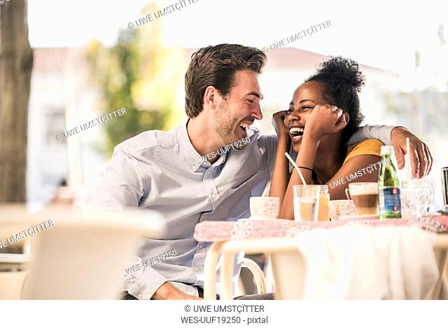 Laughing young couple at an outdoor cafe