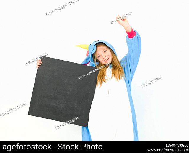 pretty blonde girl with cozy blue unicorn costume with blackboard is posing in the studio in front of white wall