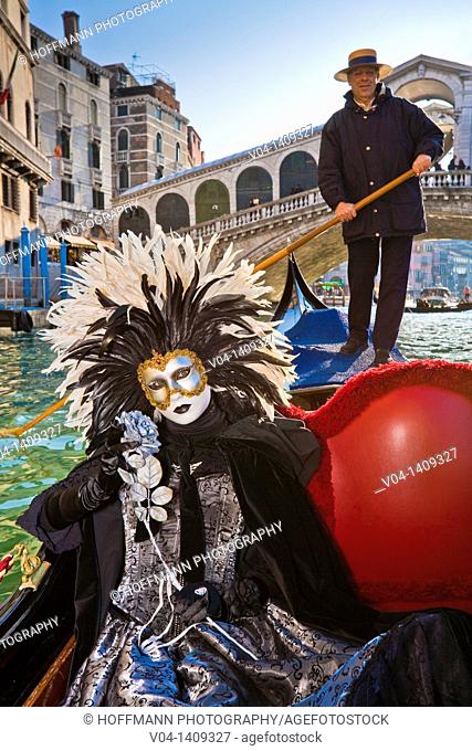 A masked woman during carnival in a gondola on the Canale Grande, Venice, Italy, Europe