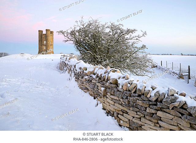 Broadway Tower and dry stone wall in winter snow, Broadway, The Cotswolds, Worcestershire, England, United Kingdom, Europe