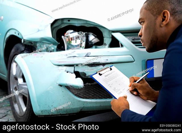 African American Car Insurance Agent Inspecting Accident Claim
