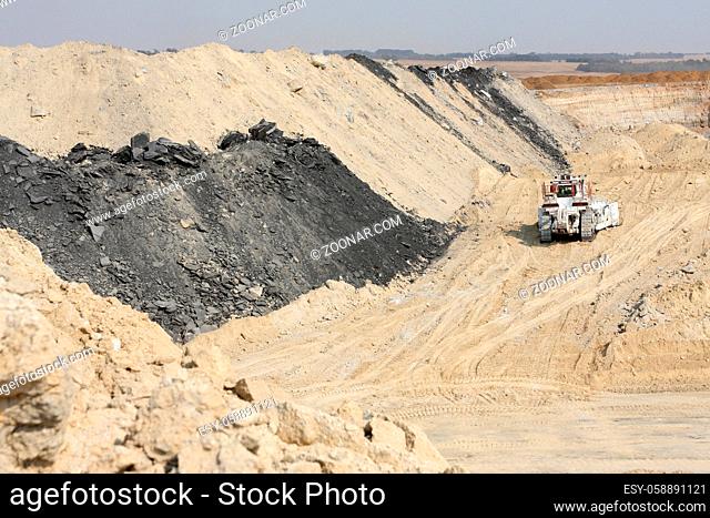 Open Pit Coal Mining - Large Rock Dump Trucks and Excavators digging and hauling in an open pit coal mine in South Africa