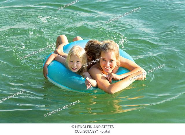 Mother with daughter and son in inflatable ring, Lake Starnberg, Bavaria, Germany