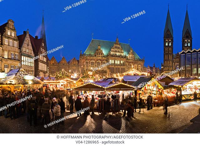 View over the christmas market at dusk. Town hall and cathedral in background. Marktplatz. Bremen, Germany