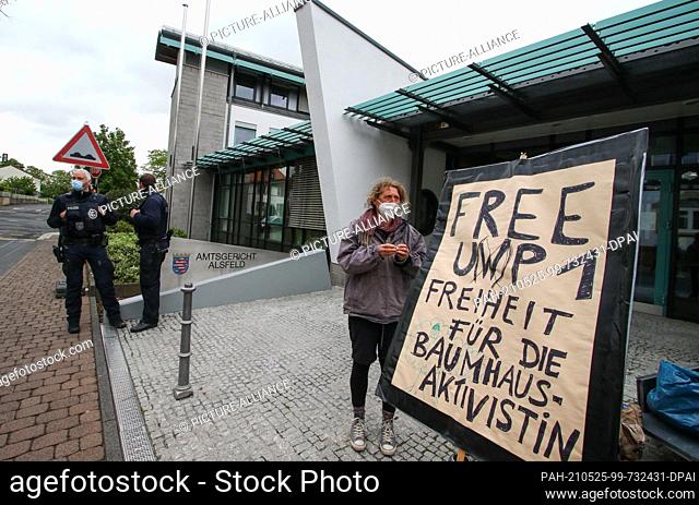 25 May 2021, Hessen, Alsfeld: With a poster, environmental activists demand the release of an accused woman in front of the district court