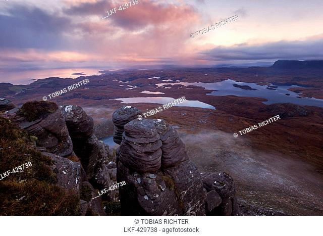 Sunrise with the view from Stac Pollaidh over the Inverpolly Nature Reserve with typical sandstone formations in the foreground