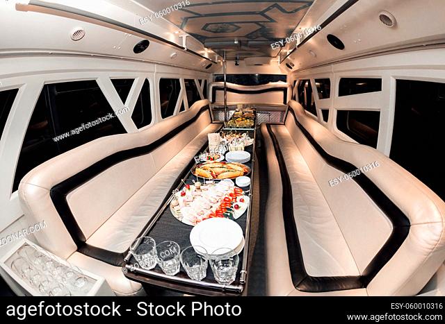Interior inside the limousine. with sofas and a table covered with snacks for the holiday. Selective focus