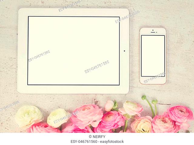 Pink and white ranunculus flowers styled flat lay scene with tablet and mobile, retro toned