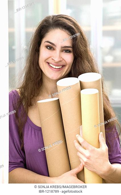 Girl holding cardboard rolls